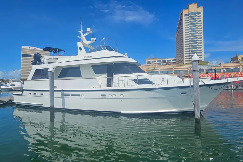 Slide: The Image of 1990 Hatteras 67 Cockpit Motor Yacht docked in a marina, clear blue sky. - 0