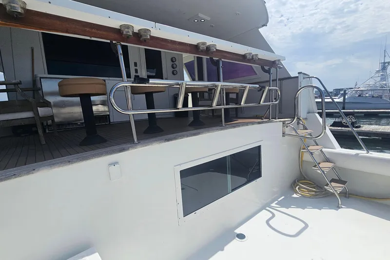 Slide: The Image of 1990 Hatteras 67 Cockpit Motor Yacht with outdoor seating and stainless steel railings. - 11