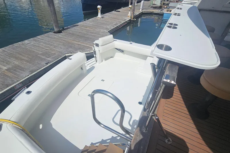 Slide: The Image of 1990 Hatteras 67 Cockpit Motor Yacht docked, featuring spacious cockpit and sleek design. - 12