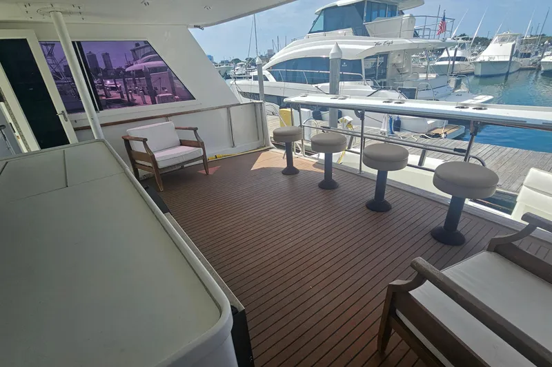 Slide: The Image of Spacious deck of 1990 Hatteras 67 Cockpit Motor Yacht with seating and marina view. - 14