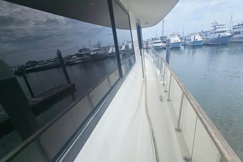 Slide: The Image of 1990 Hatteras 67 Cockpit Motor Yacht docked at marina, side view. - 15