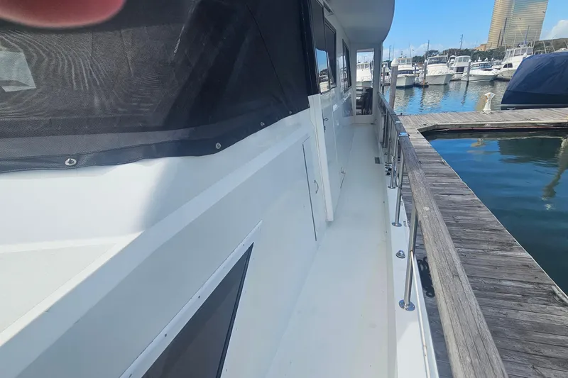 Slide: The Image of 1990 Hatteras 67 Cockpit Motor Yacht docked at marina, side view. - 20