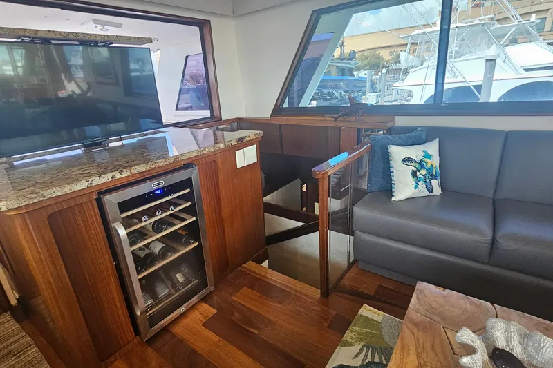 Slide: The Image of Luxurious interior of 1990 Hatteras 67 Cockpit Motor Yacht with wine cooler and seating area. - 22