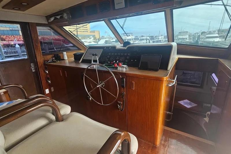 Slide: The Image of Interior helm of 1990 Hatteras 67 Cockpit Motor Yacht with wooden dashboard and steering wheel. - 24