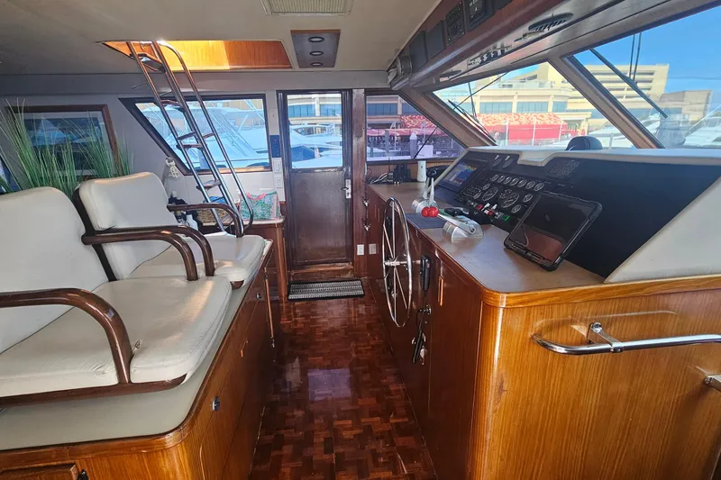 Slide: The Image of Interior of 1990 Hatteras 67 Cockpit Motor Yacht with helm and seating area. - 25