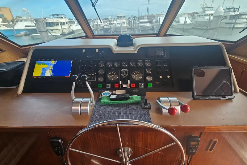 Slide: The Image of Cockpit of 1990 Hatteras 67 Cockpit Motor Yacht with navigation controls and steering wheel. - 28