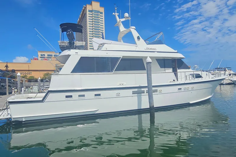Slide: The Image of 1990 Hatteras 67 Cockpit Motor Yacht docked in marina, clear sky background. - 3