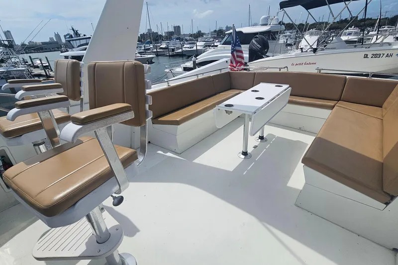 Slide: The Image of 1990 Hatteras 67 Cockpit Motor Yacht with spacious seating and table on deck. - 36
