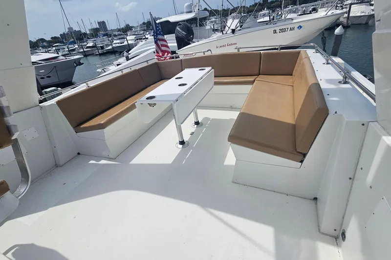 Slide: The Image of Spacious seating area on 1990 Hatteras 67 Cockpit Motor Yacht, docked at marina. - 37