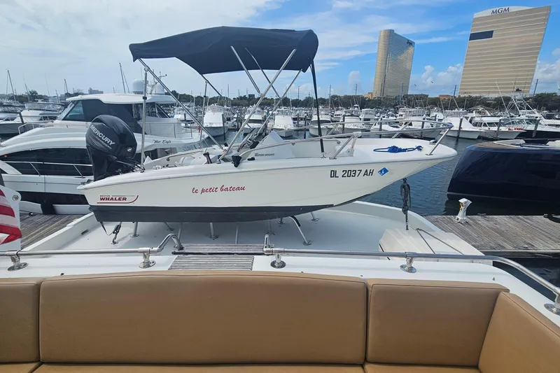 Slide: The Image of 1990 Hatteras 67 Cockpit Motor Yacht with small boat on deck, marina background. - 38