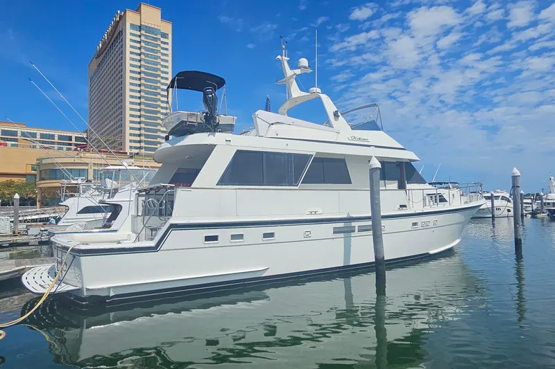 Slide: The Image of 1990 Hatteras 67 Cockpit Motor Yacht docked at marina under blue sky. - 4