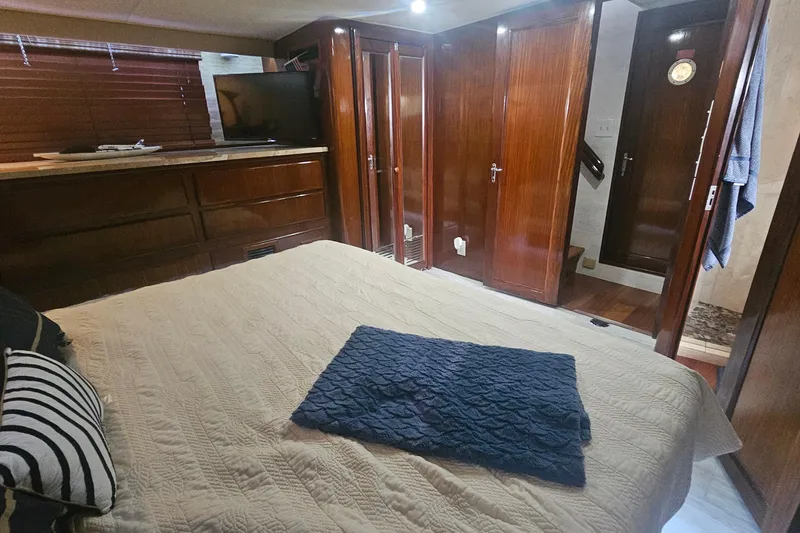 Slide: The Image of Interior of 1990 Hatteras 67 Cockpit Motor Yacht with cozy bedroom and wooden cabinetry. - 46