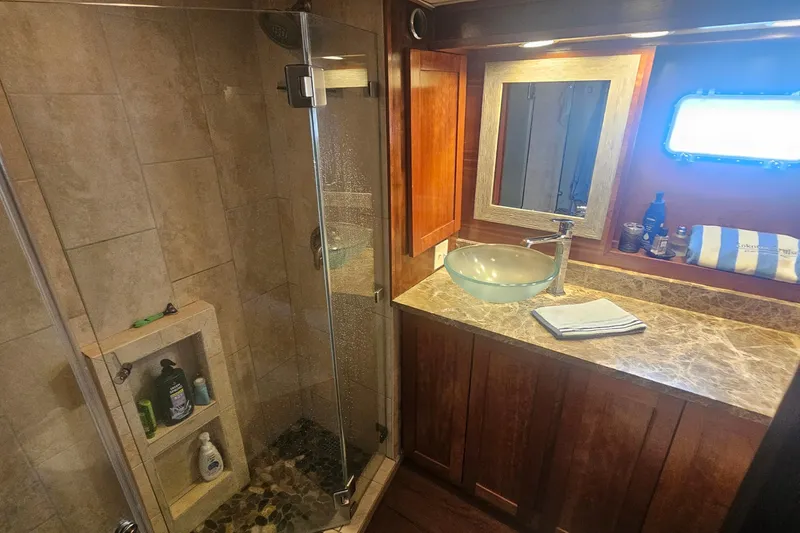 Slide: The Image of Luxurious bathroom in 1990 Hatteras 67 Cockpit Motor Yacht with glass shower and marble countertop. - 47
