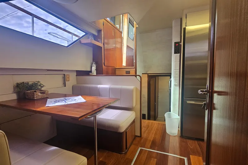 Slide: The Image of Interior of 1990 Hatteras 67 Cockpit Motor Yacht with dining area and modern kitchen. - 50