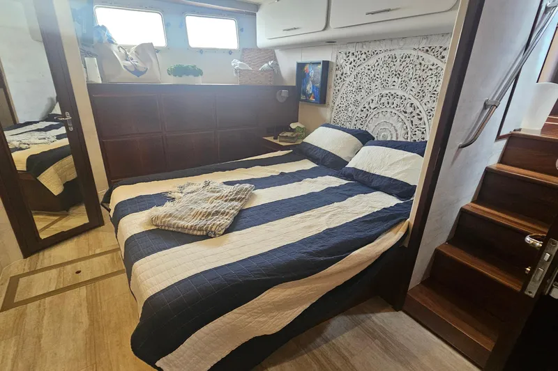 Slide: The Image of Luxurious bedroom interior of 1990 Hatteras 67 Cockpit Motor Yacht with striped bedding. - 56