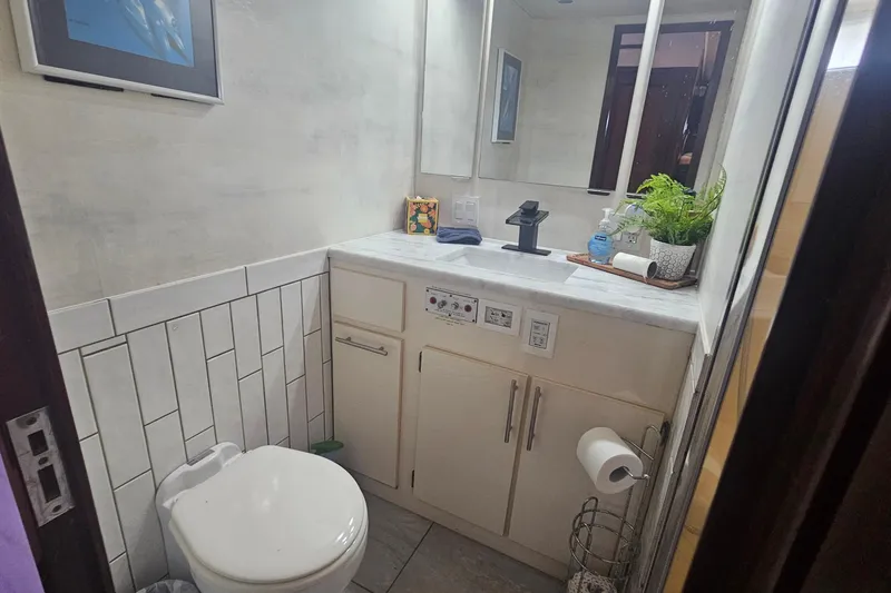 Slide: The Image of Bathroom interior of 1990 Hatteras 67 Cockpit Motor Yacht with modern fixtures and decor. - 62