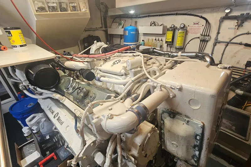 Slide: The Image of Engine room of 1990 Hatteras 67 Cockpit Motor Yacht with diesel engine components. - 64