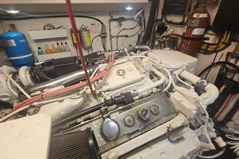 Slide: The Image of Engine room of a 1990 Hatteras 67 Cockpit Motor Yacht, showcasing mechanical components. - 68