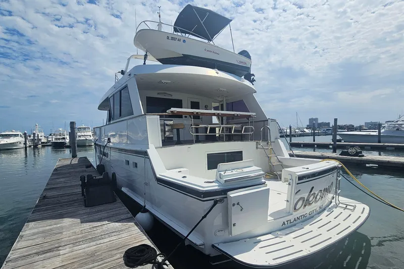 Slide: The Image of 1990 Hatteras 67 Cockpit Motor Yacht docked at marina under cloudy sky. - 7