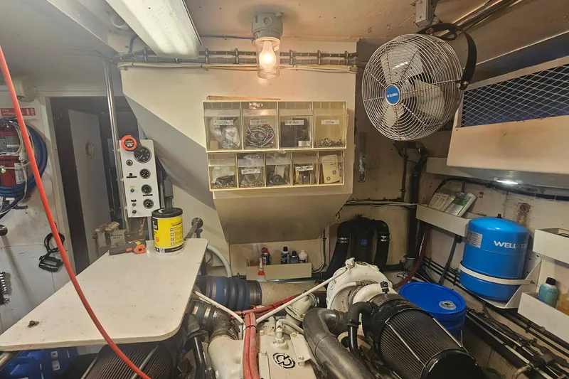 Slide: The Image of Engine room of 1990 Hatteras 67 Cockpit Motor Yacht with tools and equipment. - 70