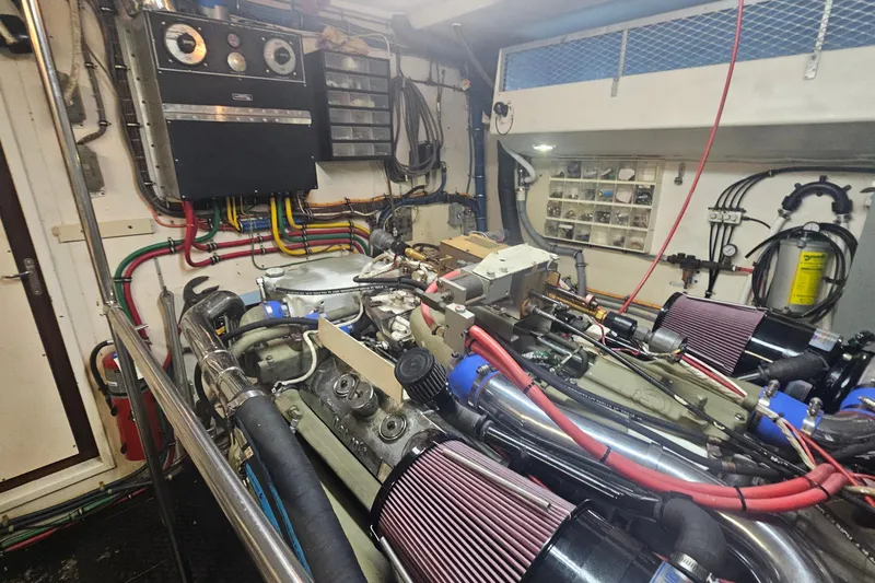Slide: The Image of Engine room of a 1990 Hatteras 67 Cockpit Motor Yacht, showcasing complex machinery and wiring. - 74
