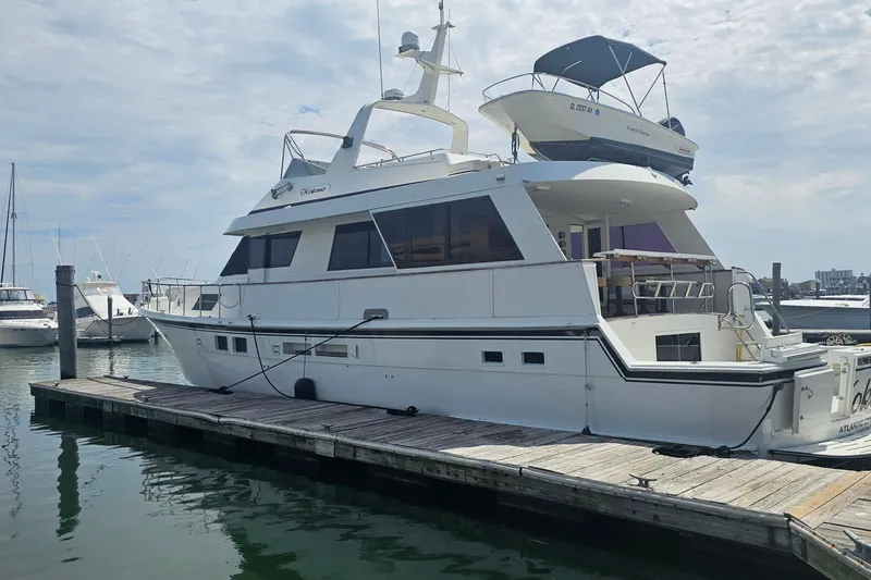 Slide: The Image of 1990 Hatteras 67 Cockpit Motor Yacht docked at marina under cloudy sky. - 8