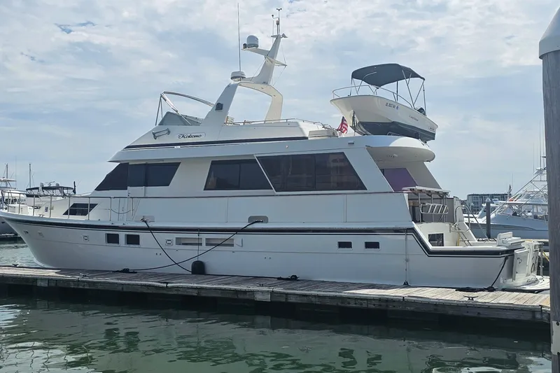 Slide: The Image of 1990 Hatteras 67 Cockpit Motor Yacht docked at marina under cloudy sky. - 9