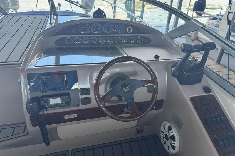 Slide: The Image of 2000 Regal Commodore 3260 boat dashboard with steering wheel and control panel. - 19