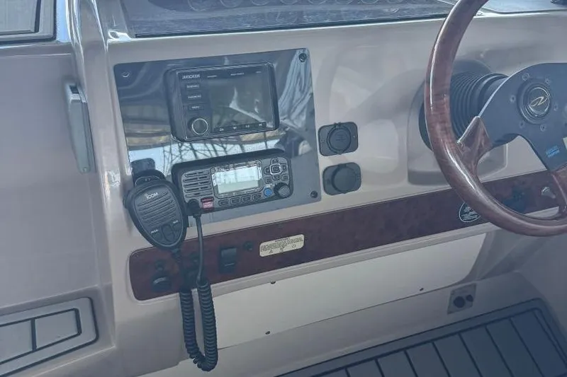 Slide: The Image of Control panel of a 2000 Regal Commodore 3260 boat with steering wheel and radio equipment. - 23
