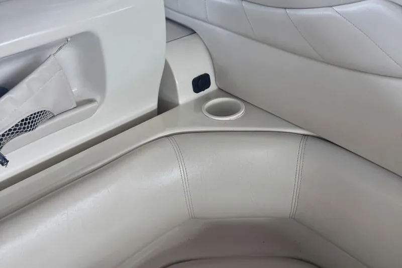 Slide: The Image of 2000 Regal Commodore 3260 boat interior with beige leather seating and cup holder. - 24