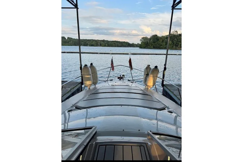 Slide: The Image of 2000 Regal Commodore 3260 yacht docked on a serene lake with scenic views. - 27