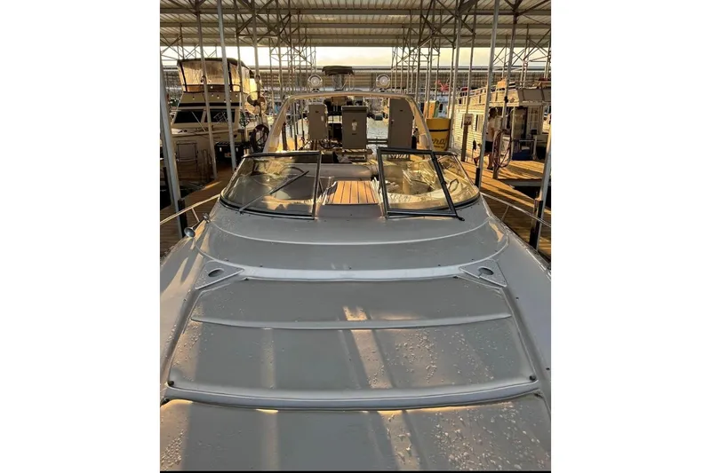 Slide: The Image of 2000 Regal Commodore 3260 boat docked in a marina under a covered structure. - 28