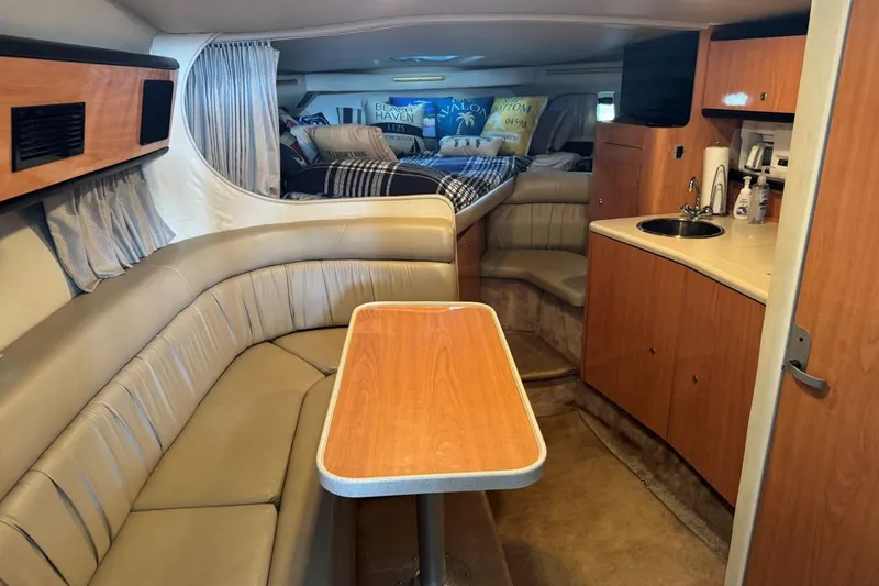 Slide: The Image of Interior of 2000 Regal Commodore 3260 yacht with seating, table, and kitchenette. - 32