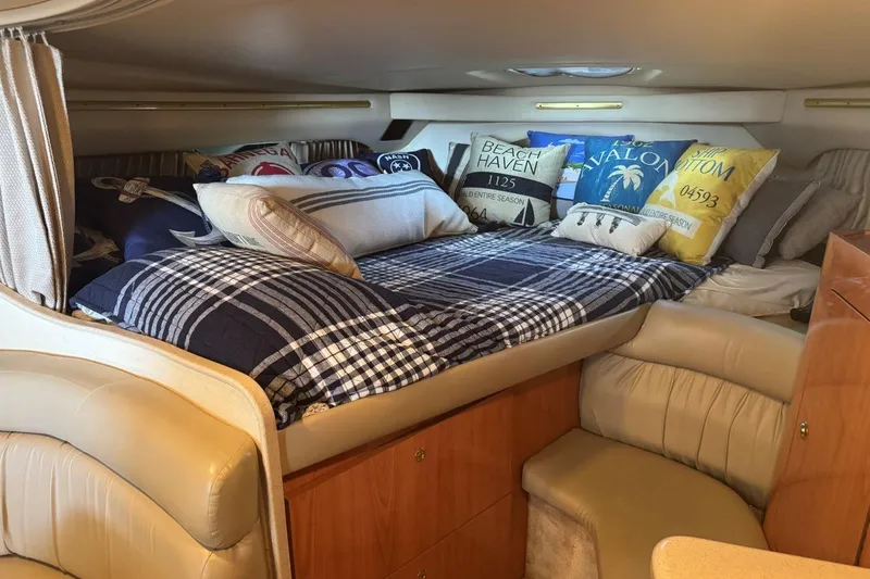 Slide: The Image of Cozy cabin interior of 2000 Regal Commodore 3260 with decorative pillows and plaid bedding. - 33