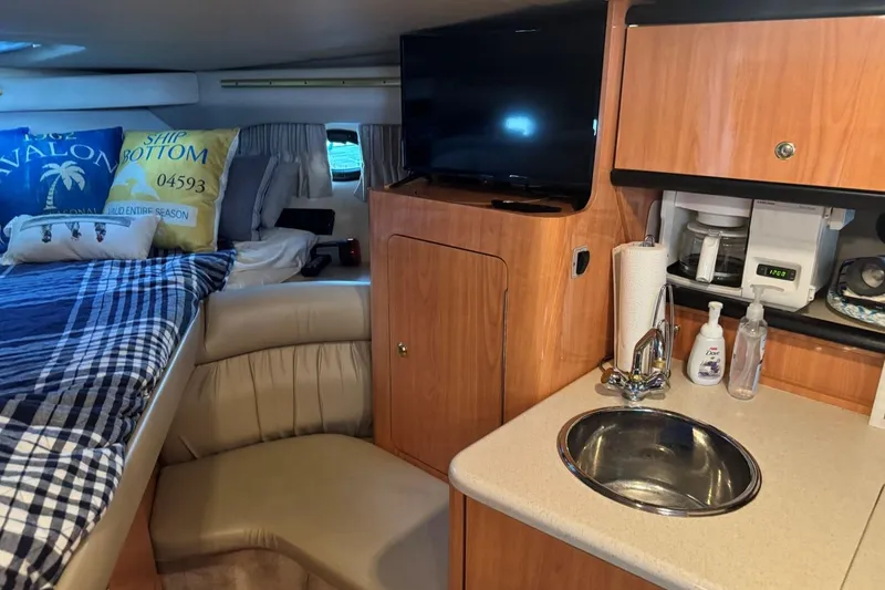 Slide: The Image of Interior of 2000 Regal Commodore 3260 yacht with cozy bed, kitchenette, and TV. - 34