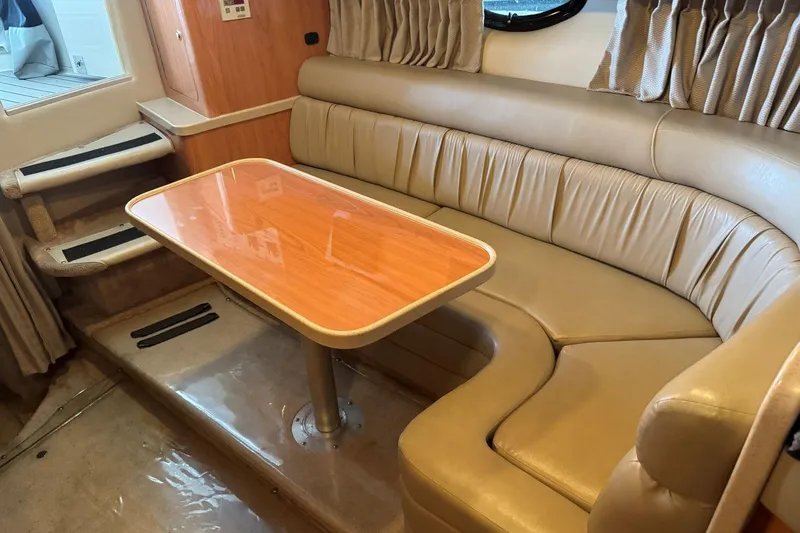 Slide: The Image of Interior of 2000 Regal Commodore 3260 yacht with leather seating and wooden table. - 35