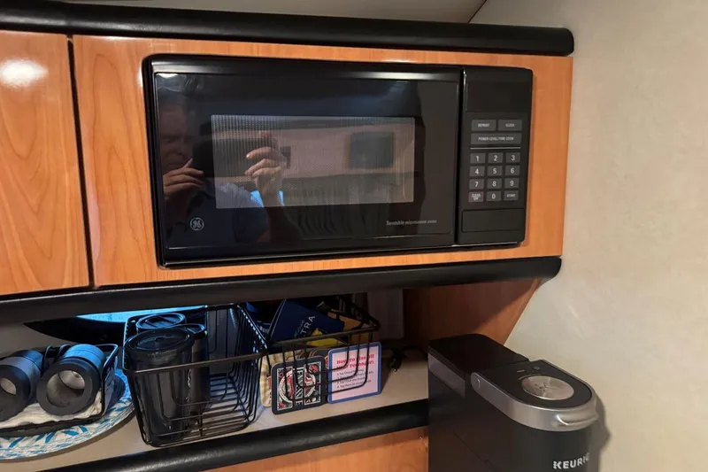 Slide: The Image of Interior of a 2000 Regal Commodore 3260 with a GE microwave and Keurig coffee maker. - 37