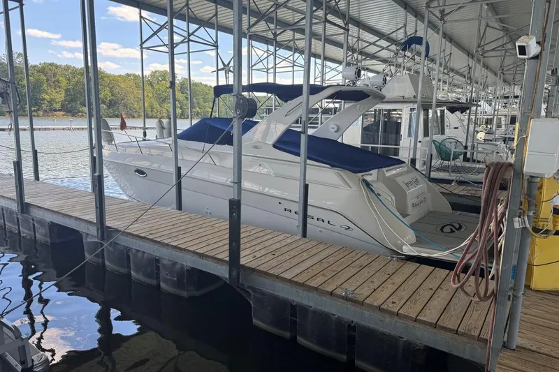Slide: The Image of 2000 Regal Commodore 3260 boat docked in a marina under a covered structure. - 49