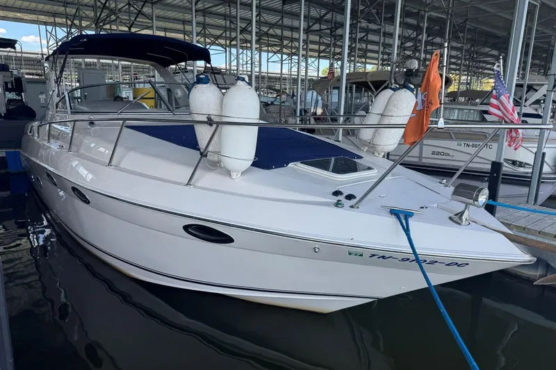 Slide: The Image of 2000 Regal Commodore 3260 boat docked in marina, featuring sleek design and white exterior. - 5