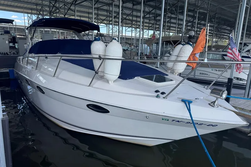 Slide: The Image of 2000 Regal Commodore 3260 boat docked in a marina, featuring a sleek white design. - 52