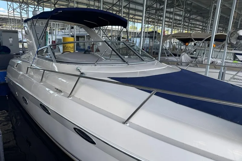 Slide: The Image of 2000 Regal Commodore 3260 boat docked in a marina, featuring a sleek white design. - 7