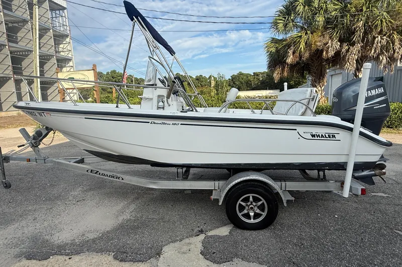 Slide: The Image of 2002 Boston Whaler 180 Dauntless boat on trailer, parked outdoors. - 18