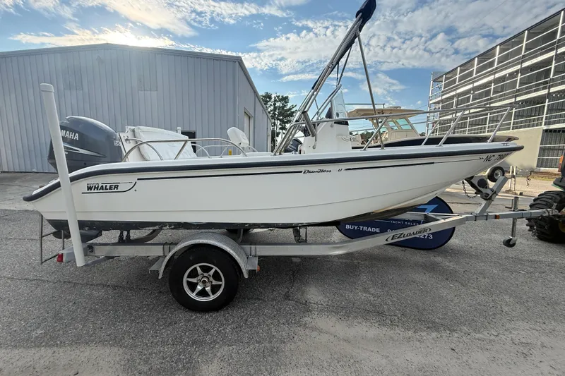 Slide: The Image of 2002 Boston Whaler 180 Dauntless boat on trailer, parked outdoors. - 22