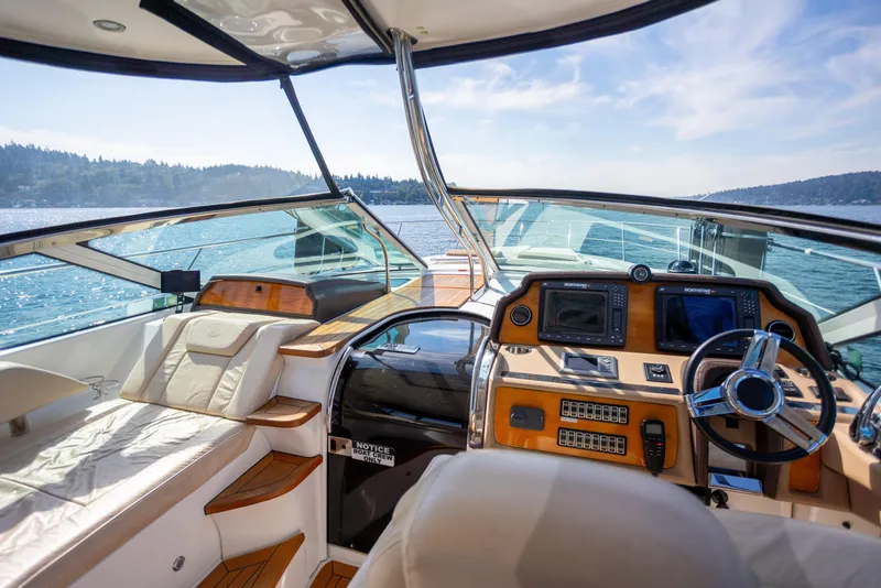 Slide: The Image of 2018 Cobalt 46 Yacht cockpit with luxurious seating and advanced navigation controls on open water. - 15