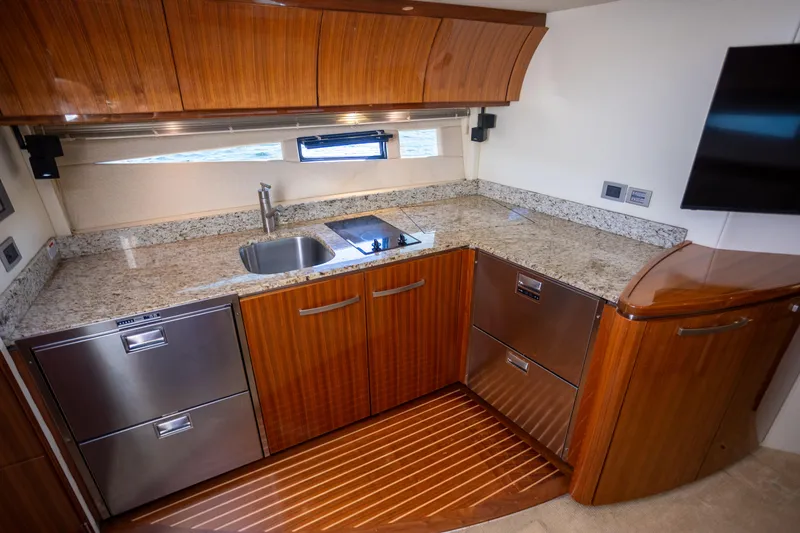 Slide: The Image of Luxurious kitchen interior of 2018 Cobalt 46 Yacht with granite countertops and wood cabinetry. - 19