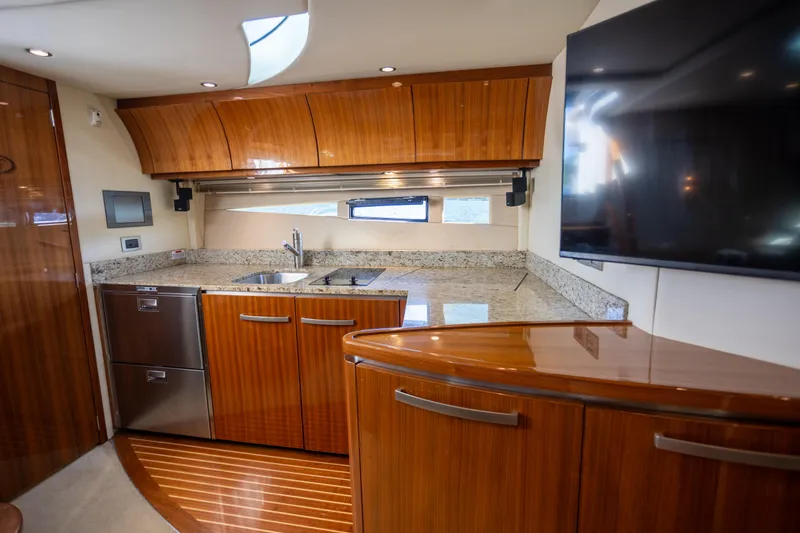Slide: The Image of Luxurious 2018 Cobalt 46 Yacht interior kitchen with sleek wood cabinetry and granite countertops. - 20