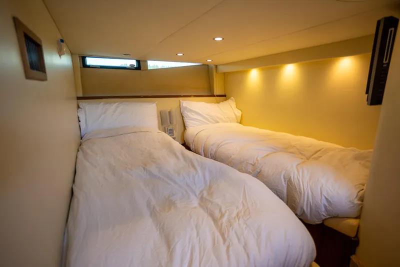 Slide: The Image of Interior of 2018 Cobalt 46 Yacht with cozy twin beds and soft lighting. - 24