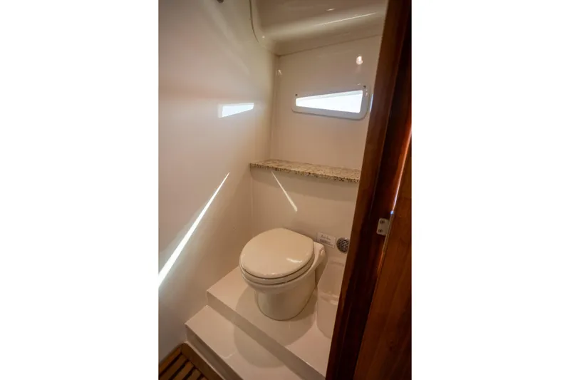 Slide: The Image of 2018 Cobalt 46 Yacht bathroom with modern toilet and small window. - 26