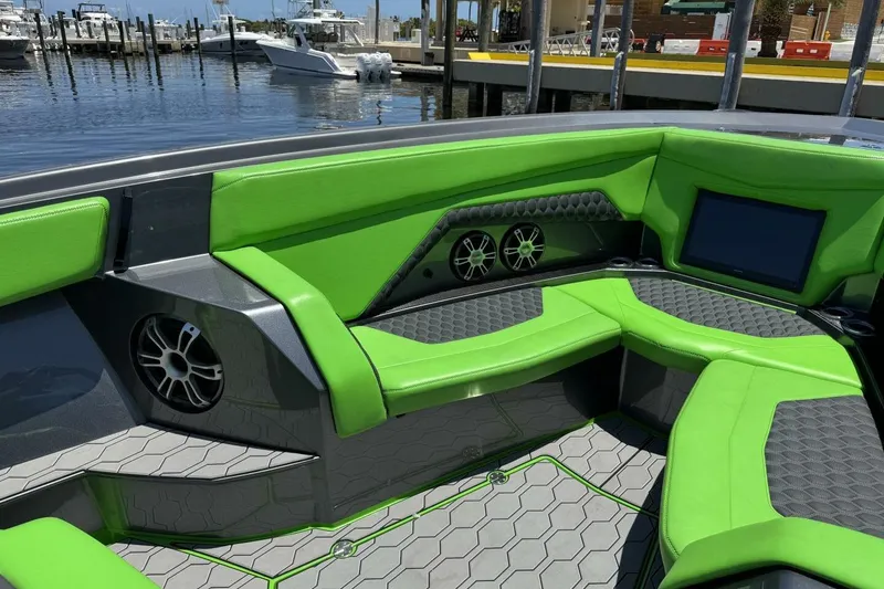 Slide: The Image of 2023 Adrenaline 47 boat interior with green seating, speakers, and a waterfront view. - 10