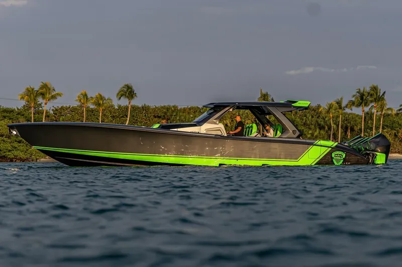 Slide: The Image of 2023 Adrenaline 47 boat cruising on water with tropical backdrop. - 3